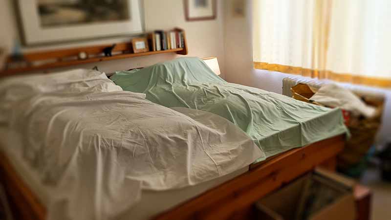 Ein gepflegtes Schlafzimmer mit Ehebett, Büchern, Billdern und kleine Erinnerungsstücke