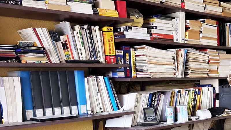 Volles Regal mit Aktenordnern, Dokumenten und Papieren